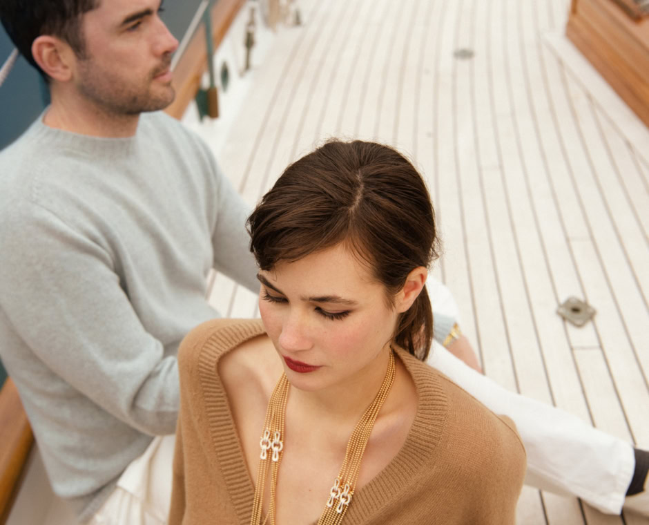 Elegant portrait of a woman and man on a yacht deck, showcasing luxury lifestyle photography with a focus on fashion, elegance, and outdoor setting.